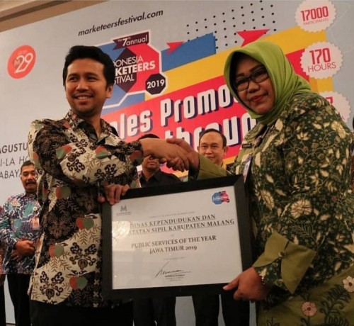 Wakil Gubernur Jatim Emil Dardak saat menyerahkan penghargaan Public Service of The Year 2019 kepada Sri Maicharini Kepala Dispendukcapil Kabupaten Malang (for MalangTIMES)
