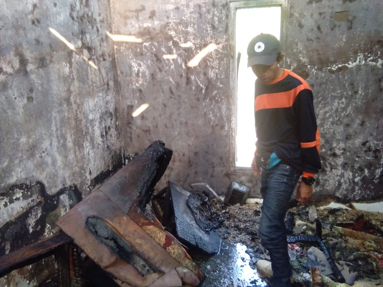 Petugas saat mengecek kondisi ruang tamu yang terbakar di Jalan Patimura RT 05 RW 07 Kelurahan Temas, Kecamatan Batu, Selasa (13/8/2019).