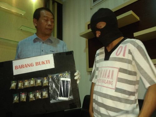 Arif Dwi Affandi (kanan) tersangka beserta barang bukti narkoba jenis ganja saat sesi rilis (Foto : Satrskoba Polres Malang for MalangTIMES)