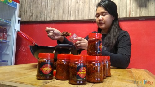 Owner Sambal Mamacih tengah mengemas sambal kemasan. (Foto: Nurlayla Ratri/MalangTIMES)