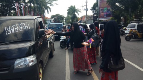 Pelaku UMKM di Banyuwangi membagikan produknya kepada pengguna jalan.