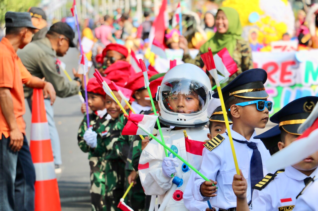 Deretan siswa yang menggunakan pakaian astronot, TNI, dan pilot di jalan protokol Panglima Sudirman, Kecamatan Batu, Kamis (15/8/2019).