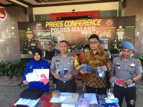 Kapolres Malang AKBP Yade Setiawan Ujung (dua dari kiri) saat menunjukkan barang bukti dalam kasus penipuan berskala internasional (Foto : Ashaq Lupito / MalangTIMES)