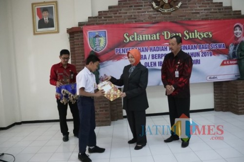 Bupati Kediri Hj Haryanti Sutrisno menyerahkan penghargaan kepada siswa berprestasi.(eko Arif s /JatimTimes)