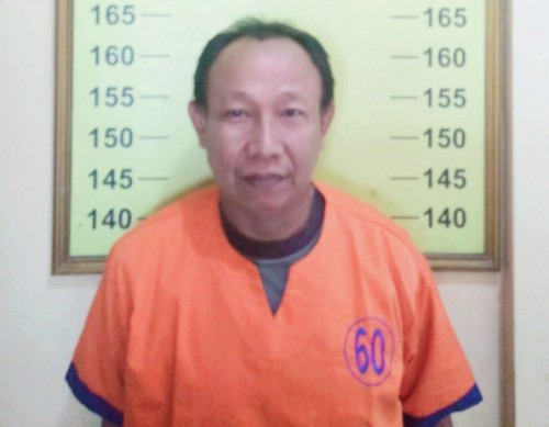 Aji Siswanto, pelaku penganiayaan Ibu RT. Kini meringkup di sel rutan Polsek Kota Banyuwangi