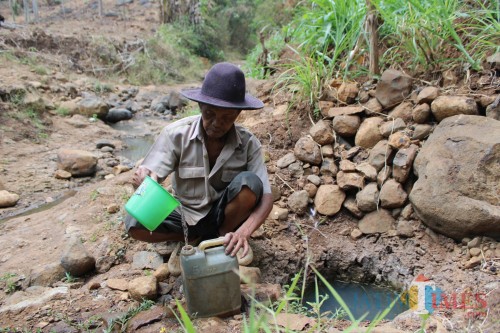 Salah seorang masyarakat desa hutan di Dusun Babatan, Desa Sumberejo, Kecamatan Wonosalam, Sumito sedang terlihat mengambil air di sungai yang mulai mengering. (Foto : Adi Rosul / JombangTIMES)