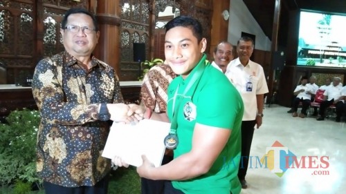 Maryoto Birowo saat berikan bonus bagi atlet angkat berat asal Tulungagng yang meraih medali dalam Porprov VI (foto : Joko Pramono/Jatim Times)