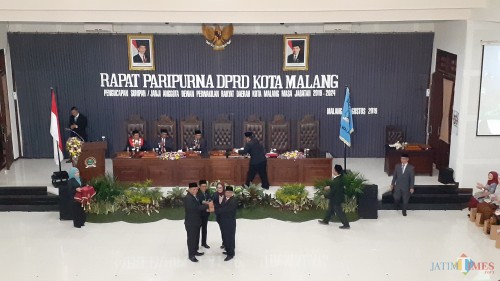 Ketua DPRD Kota Malang periode 2014-2019, Bambang Heri Susanto (kanan) saat menyerahkan palu sidang kepada Ketua Sementara DPRD Kota Malang, I Made Rian DK (kiri) (Pipit Anggraeni/MalangTIMES).