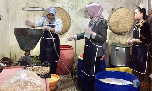 Wali Kota Batu Dewanti Rumpoko (tengah) saat akan mencoba proses penggilingan kacang kedelai di Omah Tempe di Dusun Karangjambe, Desa Beji, Kecamatan Junrejo, Jumat (23/8/2019) malam. (Foto: Irsya Richa/MalangTIMES)