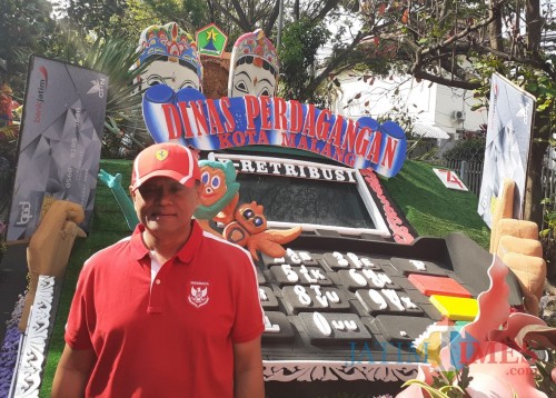 Kepala Dinas Perdagangan Kota Malang, Wahyu Setianto saat menunjukkan kendaraan Dinas Perdagangan bertema e-retribusi (Arifina Cahyanti Firdausi/MalangTIMES)