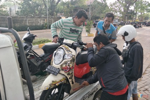 M Taufikul Hakim Persik Mania warga Pagu, Menang, Kabupaten Kediri ketika mengambil motornya yang tertahan di parkiran taman tirtoyoso. (Foto: Bambang Setioko/JatimTIMES)
