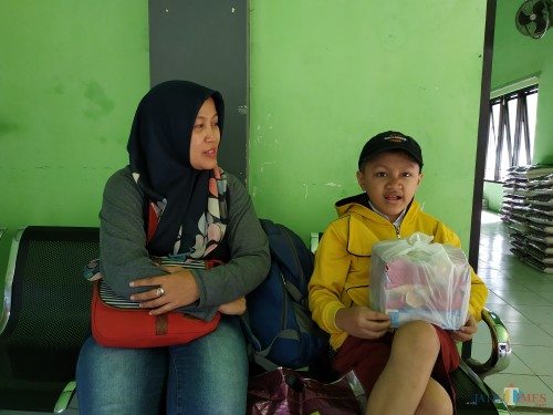 Kevin Rivelino Putra (kanan) bersama ibundanya usai menerima bantuan sosial dari Dinsos Kota Malang (Hendra Saputra)
