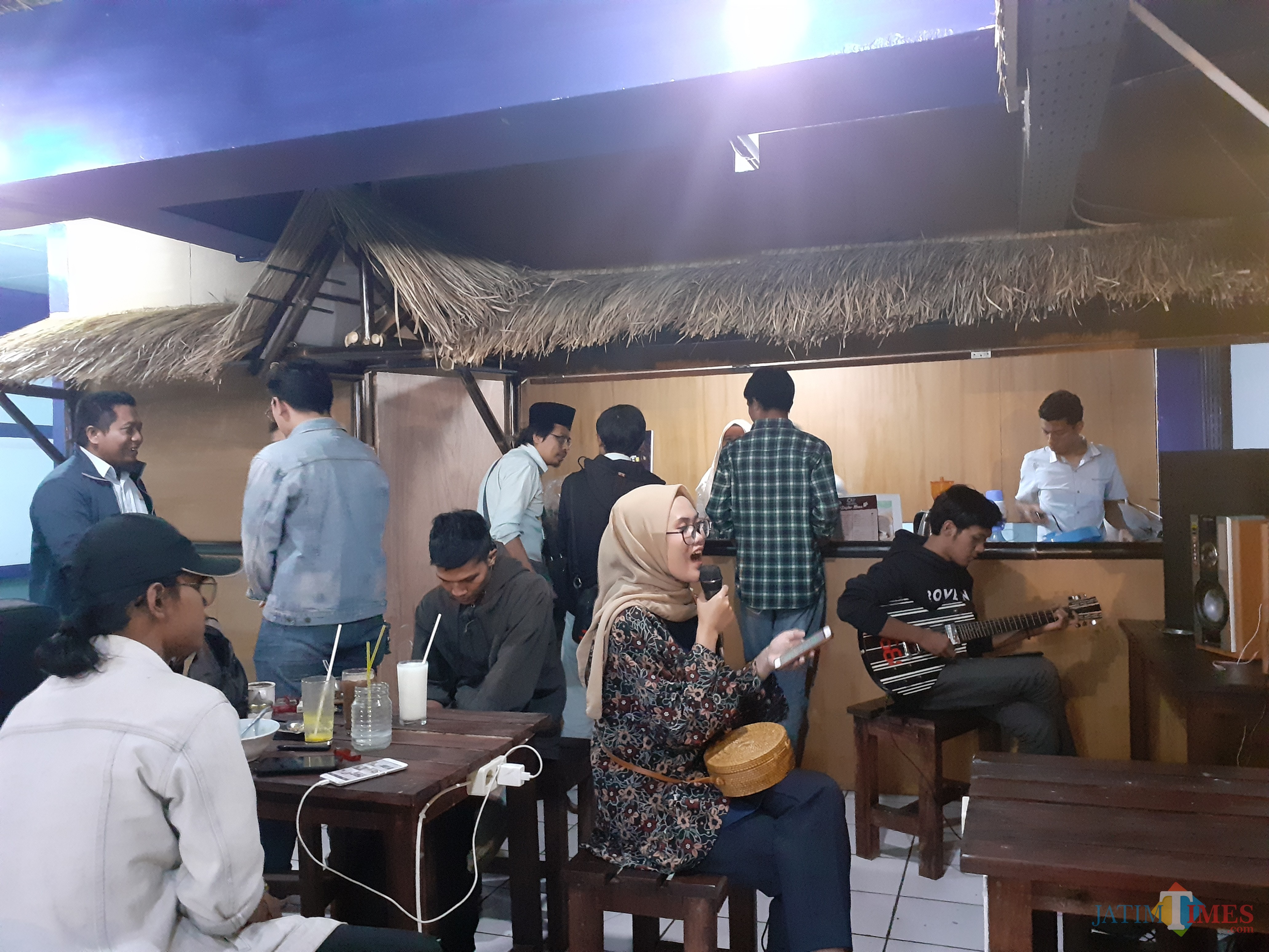 Suasana seru menyanyi dan bermain musik di Coffee Times (Arifina Cahyanti Firdausi/MalangTIMES)