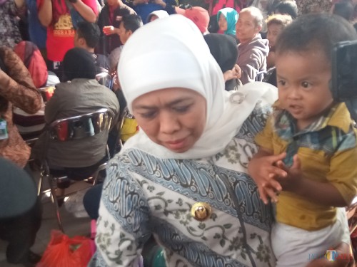 Gubernur Jatim Khofifah Indar Parawansa yang menujukkan kebahagiannya saat warganya bisa tiba dengan selamat, langsung menggendong erat salah seorang anak perantau (Anggara Sudiongko/MalangTIMES)