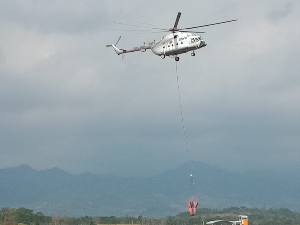 Helikopter saat membawa air di udara. (Foto: istimewa)