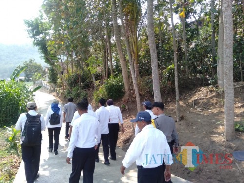 Disnaker Kabupaten Malang melihat hasil pembangunan rabat di Desa Mulyorejo, Ngantang, melalui skema padat karya infrastruktur (for MalangTimes)