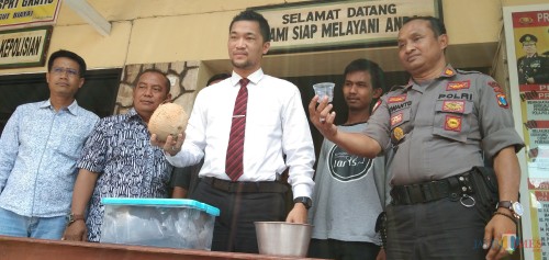 Kasat Reskrim Polres Tulungagung AKP Hendi Septiadi (kemeja putih) saat menunjukan beberapa bukti penganiayaan hewan. Azam (berkaus abu-abu) dan mayat kucing dalam kontainer. (foto : Joko Pramono/Jatim Times)