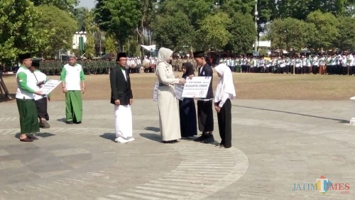 Wakil Bupati bersama Bupati Jember saat menyerahkan beasiswa kepada santri di peringatan HSN 2019 (foto : Moh. Ali Makrus / JatimTIMES)