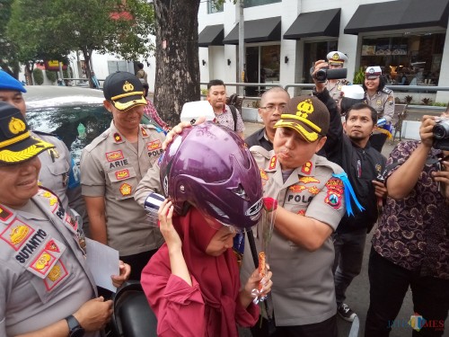 Kapolres Malang Kota, AKBP Dony Alexander saat memberikan helm kepada salah satu pengendara (Anggara Sudiongko/MalangTIMES)