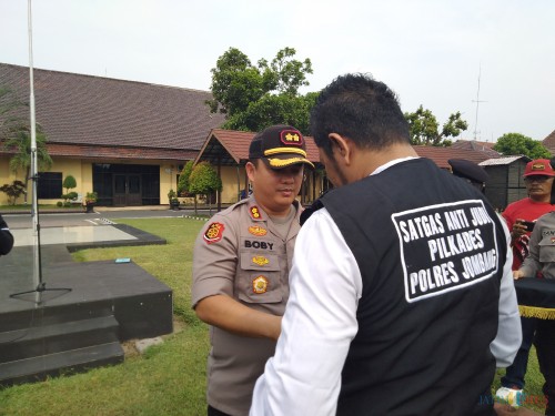 Kapolres Jombang AKBP Boby Pa'ludin Tambunan memasangkan rompi Satgas Anti Judi ke Anggotanya sebagai tanda dimulainya pengamanan Pilkades serentak di Jombang. (Foto : Adi Rosul / JombangTIMES)