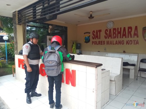 Petugas yang tengah berjaga ketat saat memeriksa salah satu pengunjung Polres Malang Kota (Anggara Sudiongko/MalangTIMES
