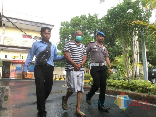 Tersangka Mugiono (tengah) saat digelandang petugas ketika sesi rilis kasus OTT pungli.(Foto : Ashaq Lupito / MalangTIMES)