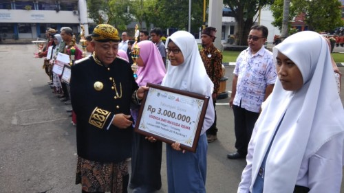 Bupati Malang HM. Sanusi (baju adat tradisional) saat memberikan apresiasi kepada para pelajar dalam upacara peringatan Hari Jadi Ke-1259 Kabupaten Malang.