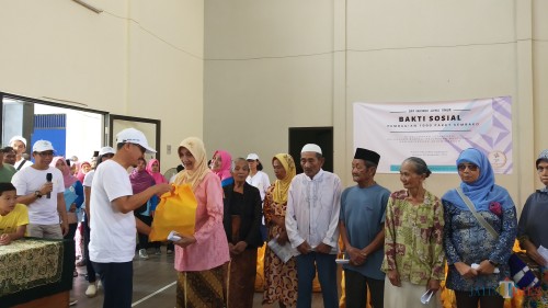 Ketua DPP Inkindo Jatim, Ir Adi Prawito (kenakan kaos putih) saat menyerahkan bantuan sembako secara simbolis kepada warga Kelurahan Lesanpuro (Pipit Anggraeni/MalangTIMES).