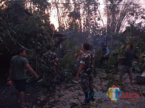 Petugas gabungan beserta warga saat berupaya mengevakuasi reruntuhan bangunan dan pepohonan setelah musibah angin kencang terjadi (Foto : Ashaq Lupito / MalangTIMES)