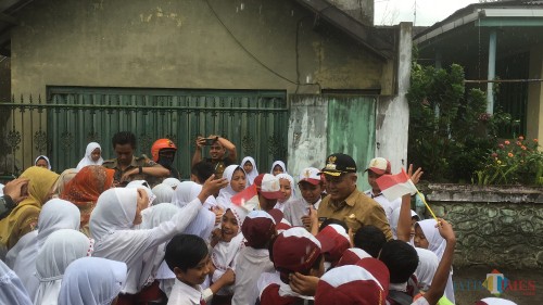 Ratusan siswa SD (Sekolah Dasar) yang ada di wilayah Kecamatan Poncokusumo saat menyambut dengan antusias kedatangan Bupati Malang HM Sanusi (baju coklat) (Foto : Ashaq Lupito / MalangTIMES)