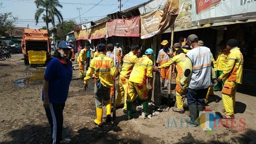 Kepala DLH Kota Malang, Rinawati saat memantau anggotanya membersihkan selokan di Pasar Blimbing (Hendra Saputra)