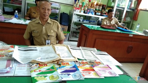 Wakasek Kesiwaan SMPN 2 Tulungagung tunjukan buku yang digunakan untuk Bimbel (foto : Joko Pramono/Jatim Times)