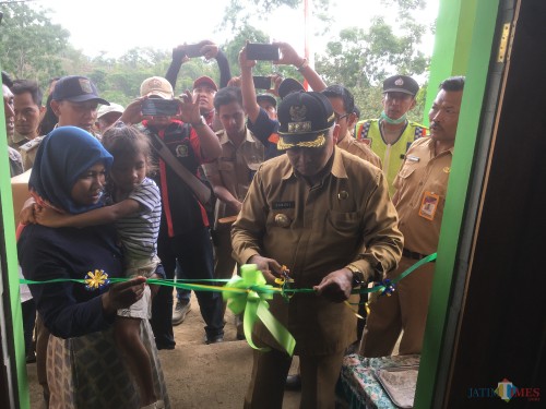 Bupati Malang HM. Sanusi (potong pita) saat meresmikan program bedah rumah yang direalisasikan DPKPCK Kabupaten Malang (Foto : Ashaq Lupito / MalangTIMES)