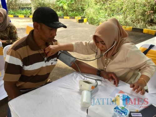 Salah satu warga saat ditensi tekanan darahnya oleh petugas di area Sumber Binangun, Desa Bumiaji, Kecamatan Bumiaji, Rabu (4/12/2019). (Foto: Irsya Richa/MalangTIMES)