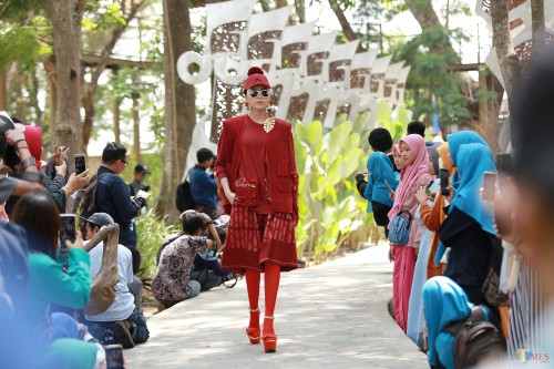 Seorang model nampak berjalan mengenakan busana tenun ikat Kediri dalam Gelaran Dhoho Street Fashion ke-5 di Hutan Joyoboyo Kota Kediri Jawa Timur, Kamis (05/12/2019) Pagi. (Foto: Bambang Setioko/JatimTIMES)