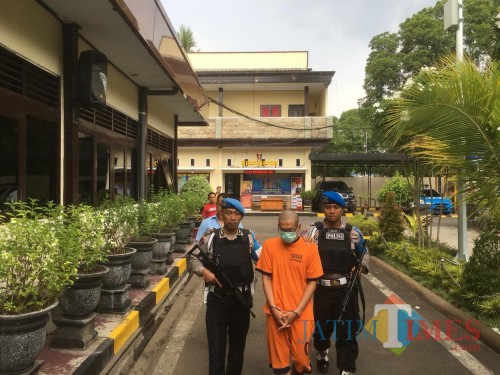 CH (tengah baju oranye) tersangka kasus pencabulan dan pemalsuan ijazah saat digelandang menuju ruang penyidikan Polres Malang (Foto : Ashaq Lupito / MalangTIMES)