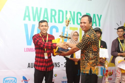 Muhammad Ali, mahasiswa Unikama yang menjuarai lomba vlog, saat menerima piala juara dari panitia. (Unikama for MalangTIMES)