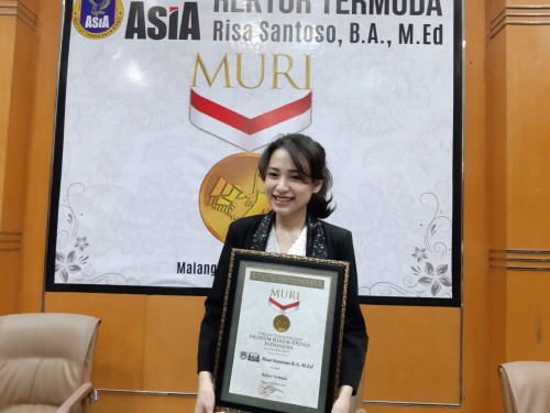Risa Santoso saat memegang penghargaan dari MURI sebagai rektor termuda (Hendra Saputra)