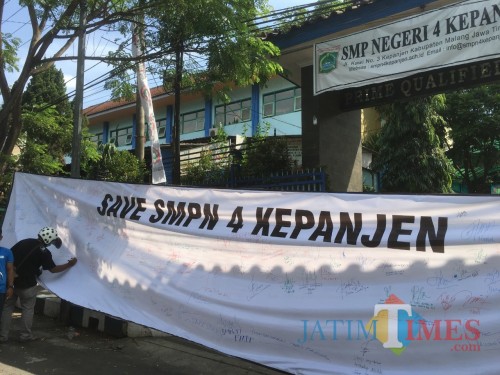 Baner aksi damai yang terbentang di depan pintu masuk SMPN 4 Kepanjen (Foto : Ashaq Lupito / MalangTIMES)
