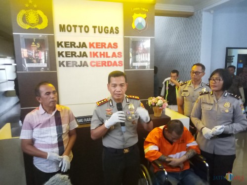 Kapolres Malang Kota, AKBP Leonardus Sinarmata, saat merilis tahanan kabur yang tertangkap. Sementara itu, Sokib nampak tertunduk dan terduduk di kursi roda usai mendapat hadiah timah panas (Anggara Sudiongko/ MalangTIMES)