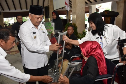 Bupati Malang HM Sanusi (tengah pakai peci) saat menyerahkan bantuan sosial kepada kaum difabel saat menghadiri agenda peringatan HKSN