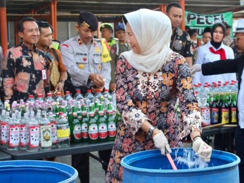 Wali Kota Batu Dewanti Rumpoko saat memecahkan botol minuman keras di halaman Plaza Batu, Kecamatan Batu, Kamis (19/12/2019).