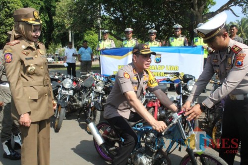 Kapolres Jember AKBP. Alfian Nurrizal SH. SIK. MH saat mencoba kendaraan yang diamankan dari aksi balap liar (foto : istimewa / Jatim TIMES)