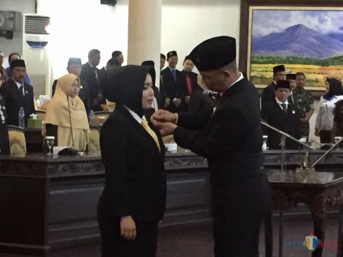 Ketua DPRD Kota Batu Asmadi saat menyematkan pin kepada Susanti di Gedung DPRD Kota Batu, Senin (30/12/2019). (Foto: Irsya Richa/MalangTIMES)