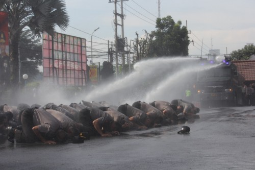 Tampak para polisi tengah sujud disemprot water canon. (ist)