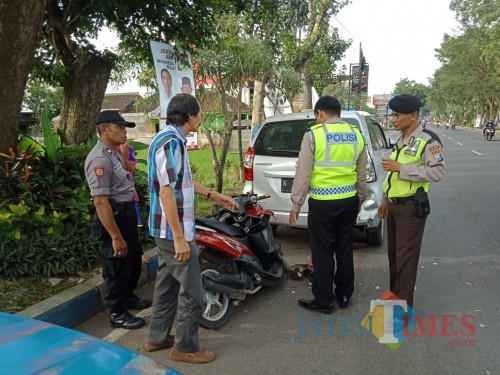 Anggota kepolisian saat melakukan olah TKP sekaligus mengevakuasi salah satu korban kecelakaan yang meninggal dunia akibat terlibat kecelakaan (Dokumen MalangTIMES)
