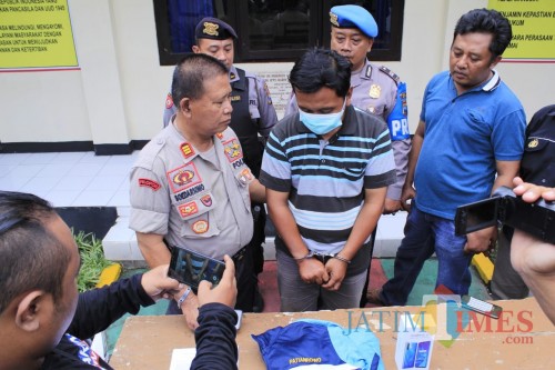 Tersangka diapit petugas saat press rilis di Mapolsek Plosoklaten. (Eko Arif S /JatimTIMES)