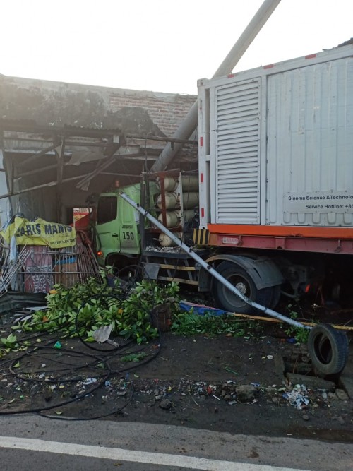 Kondisi truk kontainer yang menabrak bangunan kosong di jalan nasional Jombang. (Istimewa)