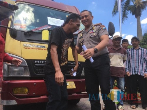 Mulyadi korban penipuan dan penggelapan (kaos hitam) saat menerima truk miliknya yang sempat dijadikan barang bukti oleh polisi (Foto : Ashaq Lupito / MalangTIMES)