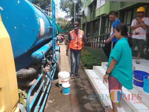 Warga Rumah Susun Sederhana Sewa (Rusunawa) Buring II saat mengantre untuk mengambi air dari tangki Perumda Tugu Tirta Kota Malang (Arifina Cahyanti Firdausi/MalangTIMES)